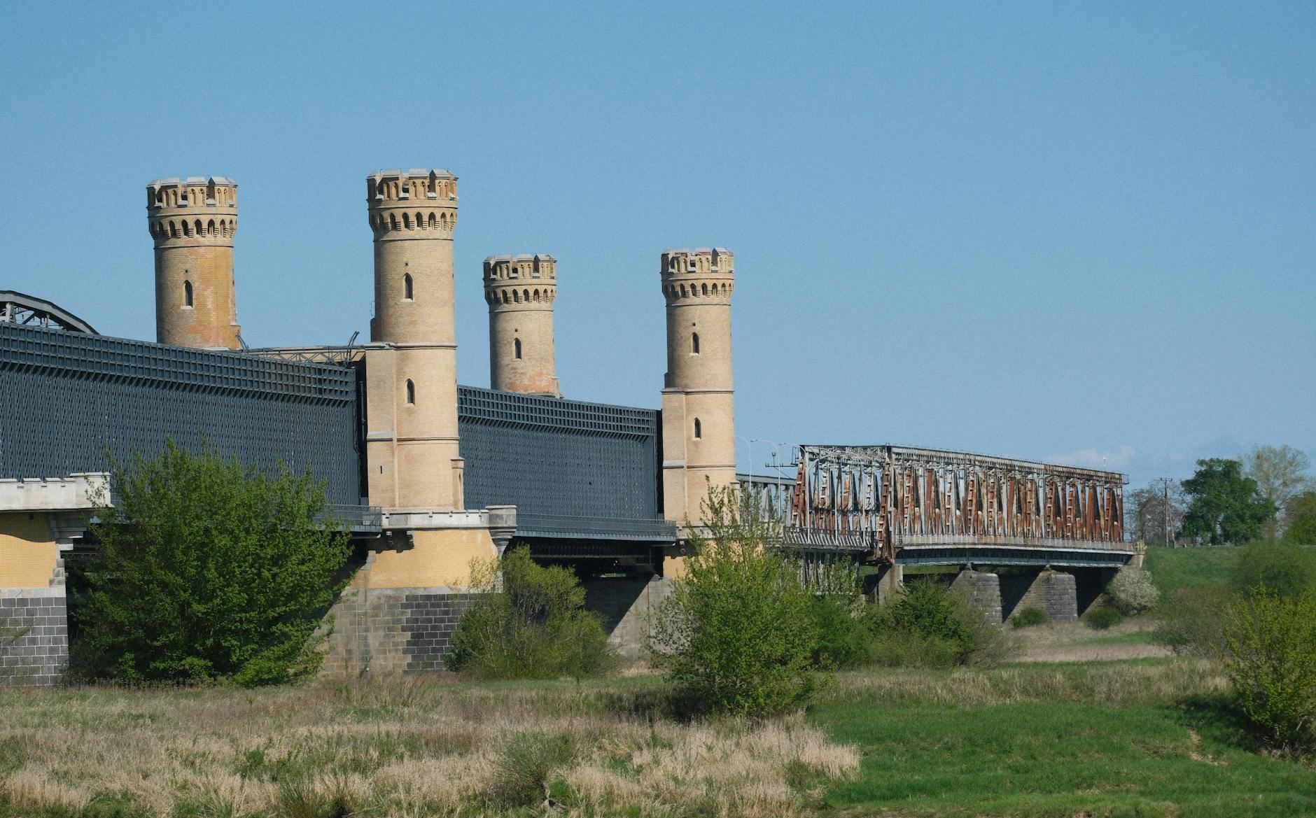 Malowniczy widok na twierdzę w Kostrzynie nad Odrą, otoczoną zielenią, sugerujący tajemniczą atmosferę.